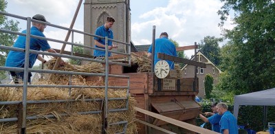 80-2 De garven ( bossen koren) worden boven in de dorsmachine gegooid.jpg