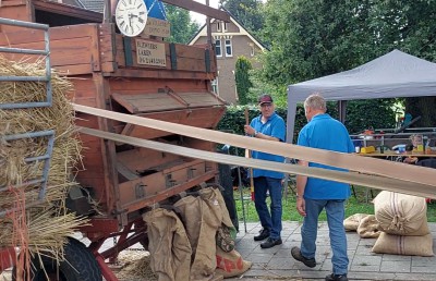 80-3 Het gedorste zaad en kaf komt gescheiden uit de machine en gaat in zakken (aan de voorkant).jpg